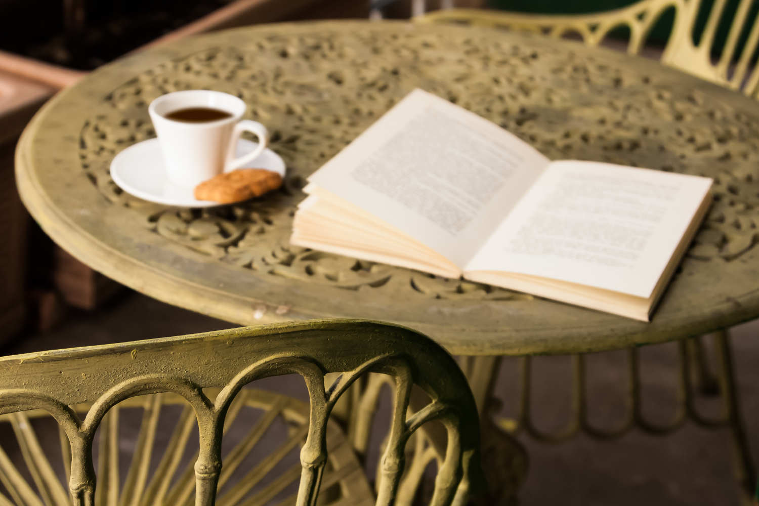 Un libro e un caffe' sopra un tavolino di metallo sfarzoso